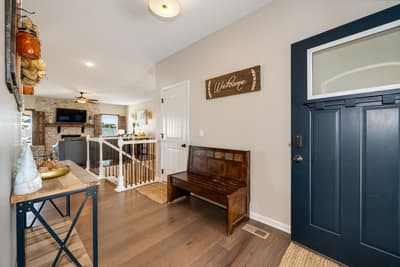 Step into your welcoming entryway where rustic charm meets modern comfort, featuring a cozy wooden bench and warm lighting that sets the perfect tone.