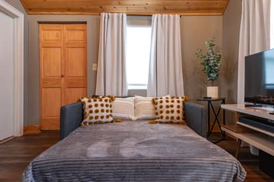 Sink into your comfortable sofa bed while enjoying natural light and warm wood touches that make this space feel like home.