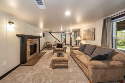 Sink into plush sofas by the stone fireplace where cozy evenings unfold with crackling flames and soft lamplight warming your retreat.