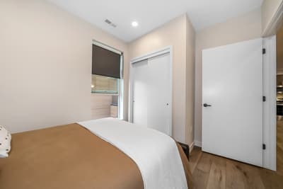 Rest peacefully in your serene bedroom featuring crisp linens, warm wood floors, and convenient closet storage for all your belongings.
