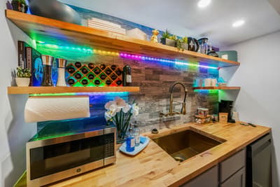 Your stylish kitchen features warm wood counters, vibrant LED lighting, and everything you need to craft memorable meals during your stay.