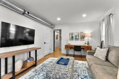 Unwind in your stylish living room with plush seating, modern workspace, and entertainment center for productive days and cozy evenings.