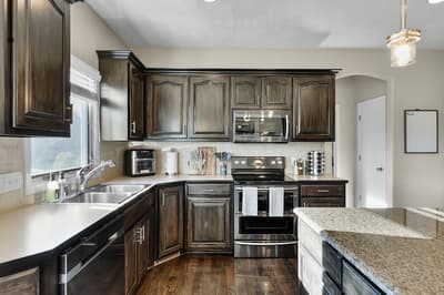 Your fully-equipped kitchen features rich dark cabinetry, granite counters, and stainless appliances perfect for preparing memorable meals together.