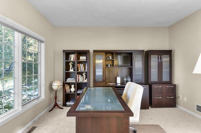 Your private office awaits with elegant wood furniture, built-in storage, and peaceful garden views to inspire productive work sessions.