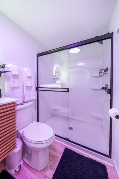 Step into your sleek modern bathroom with a spacious walk-in shower and thoughtful touches like fresh towels waiting for you.