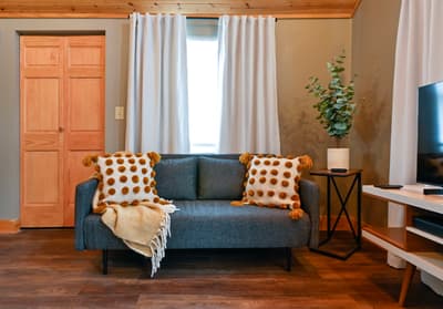 Sink into the plush sofa with cozy throw pillows and soft lighting streaming through your window for perfect relaxation.