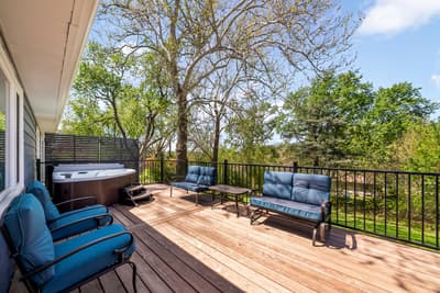 Unwind on your private deck with hot tub, comfortable seating, and peaceful tree-lined views for the perfect outdoor retreat.