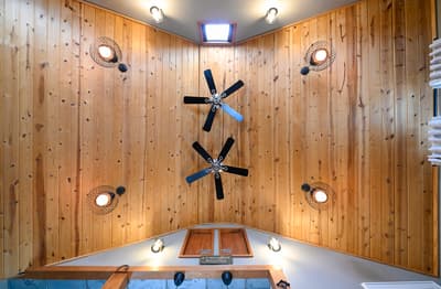 Relax beneath stunning wood-paneled ceilings with decorative fans that keep you cool while unique lighting creates the perfect ambiance.