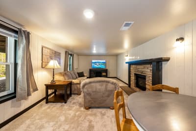 Unwind in your cozy living space with plush seating, crackling fireplace, and entertainment center for perfect evening relaxation.