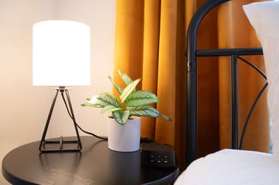 Rest easy at your stylish bedside, where warm golden curtains and soft lighting create the perfect ambiance for relaxation.
