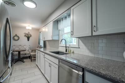 Your modern kitchen features granite countertops, stainless appliances, and subway tile backsplash, perfect for preparing home-cooked meals.