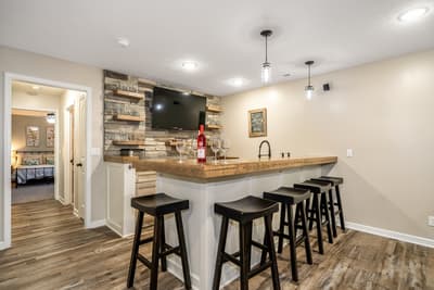 Gather around your stylish home bar with rustic stone accents and rich wood counters, perfect for evening drinks and memorable conversations.