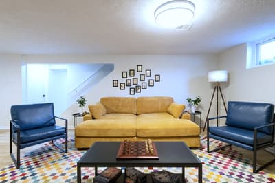 Sink into the plush golden sofa and unwind in your stylish living space, complete with a chess set for cozy game nights.
