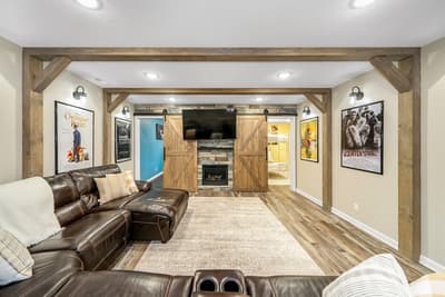 Sink into plush leather seating in your private cinema room, complete with rustic barn doors and cozy fireplace for perfect movie nights.