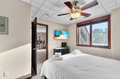 Relax in your peaceful bedroom with crisp linens, ceiling fan, and tropical views on the wall-mounted TV.