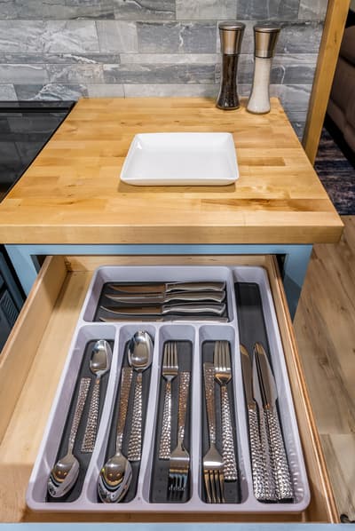 Your beautifully organized kitchen features quality utensils neatly arranged in drawers, ready for your culinary adventures.