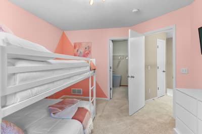 Your kids will love this cheerful coral bedroom with bunk beds and private bathroom access—perfect for family adventures.