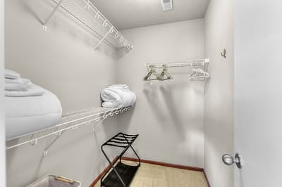Your private walk-in closet offers abundant storage with wire shelving, hangers, and space to organize your wardrobe comfortably during your stay.
