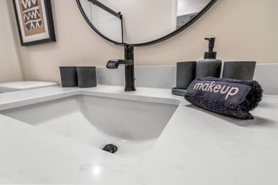 Your stylish bathroom features elegant black fixtures and thoughtful amenities, including plush towels for your comfort.