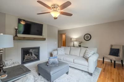 Unwind in your cozy living room featuring a warm fireplace, plush seating, and modern amenities for perfect relaxation.