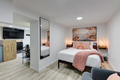 Unwind in your cozy bedroom with soft coral accents, warm lighting, and thoughtful touches that create the perfect retreat.