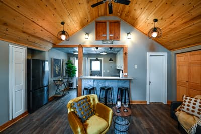 Cozy up in this rustic-modern retreat where warm wood ceilings and thoughtful lighting create your perfect home base for relaxation.