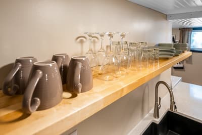 Your fully-stocked kitchen shelves hold everything you need, from elegant glassware to coffee mugs, making meal prep and entertaining effortless.