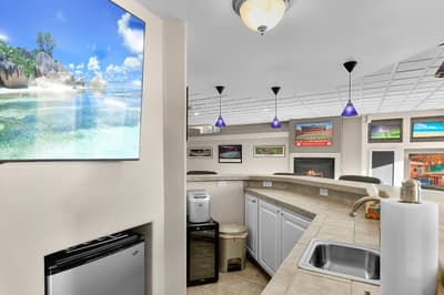 Your kitchen features modern appliances and a cozy fireplace, while the large screen creates an immersive tropical escape.