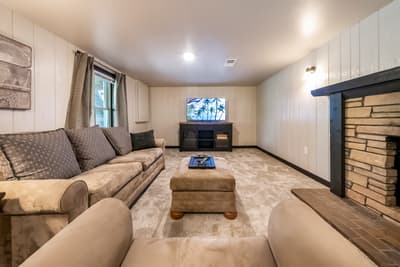 Relax in your cozy living room with plush seating, entertainment center, and charming fireplace for perfect evenings in.