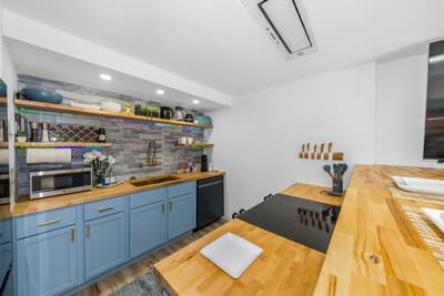 Your modern kitchen features beautiful blue cabinetry, warm wood countertops, and everything you need to create delicious meals during your stay.