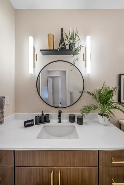 Refresh in your stylish bathroom featuring warm lighting, modern fixtures, and thoughtful touches like fresh greenery that create a spa-like atmosphere.