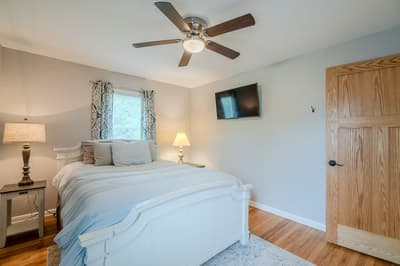 Drift off in your cozy bedroom with plush bedding, gentle ceiling fan, and wall-mounted TV for relaxing evenings.