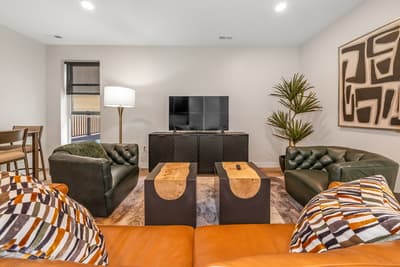 Sink into modern comfort in your stylish living space, where rich leather meets warm wood and contemporary art creates the perfect atmosphere for relaxation.