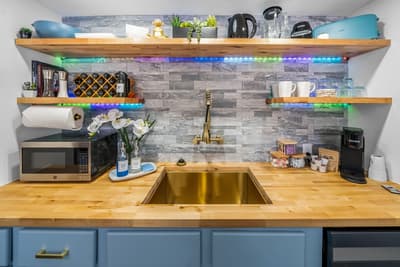 Your stylish kitchen features warm wood counters, colorful LED lighting, and everything you need to whip up delicious meals during your stay.