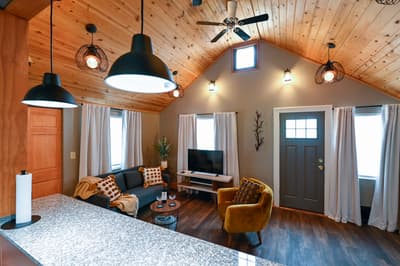 Unwind in your stylish living space with soaring wood ceilings, cozy seating, and warm lighting that creates the perfect atmosphere for relaxation.