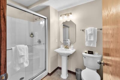 Your private bathroom features a spacious walk-in shower, elegant pedestal sink, and fluffy towels for a refreshing start to your day.