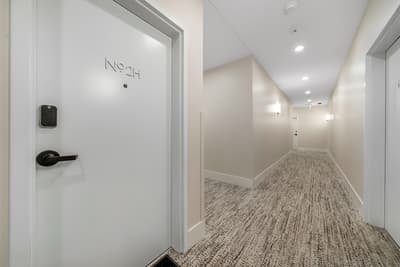 Modern hallway with sleek design leads to your private retreat, featuring keyless entry and contemporary finishes throughout.