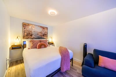 Your cozy bedroom retreat features crisp linens, warm wood accents, and a comfortable seating area for ultimate relaxation.