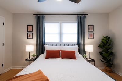 Settle into your peaceful bedroom sanctuary with crisp linens, warm bedside lighting, and natural sunlight streaming through elegant curtains.