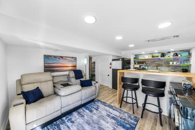 Unwind in your modern living space with plush seating, coastal artwork, and a stylish kitchen bar perfect for morning coffee.