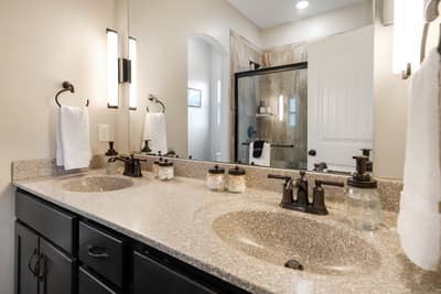 Your spacious bathroom features dual vanities with granite countertops, elegant fixtures, and a luxurious walk-in shower for ultimate comfort.