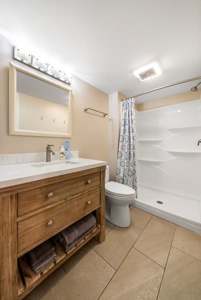 Your private bathroom features a spacious walk-in shower, elegant vanity with ample storage, and fresh towels ready for your stay.