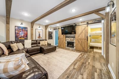 Cozy up in your rustic entertainment haven with leather seating, exposed beams, and a warm fireplace for perfect movie nights.