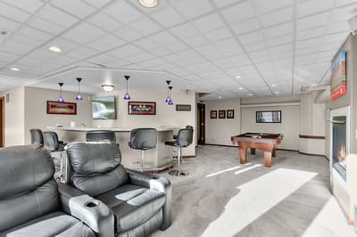 Relax in your spacious entertainment lounge with plush leather seating, full bar, pool table, and cozy fireplace for memorable evenings.