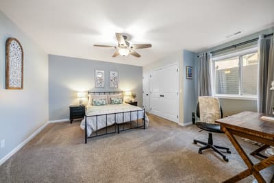 Relax in your peaceful bedroom with soft blue accents, cozy bedding, and a dedicated workspace for when you need to catch up.