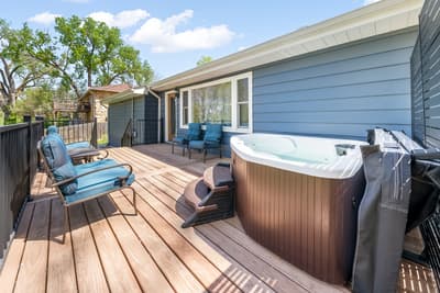 Soak in your private hot tub on this spacious deck, surrounded by comfortable seating for ultimate relaxation under the sky.