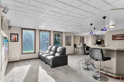 Unwind in your private entertainment space with plush leather seating, a custom bar, and game area perfect for memorable evenings.