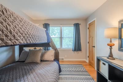 Sleep soundly in this cozy bunk room where comfort meets style. Soft quilted bedding and warm lighting create your perfect retreat.