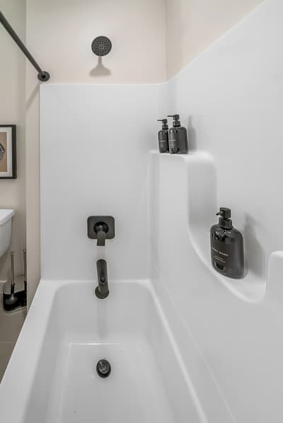 Refresh in your modern tub-shower combo with premium toiletries and sleek black fixtures for ultimate relaxation.