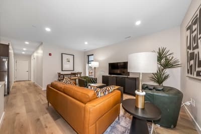 Unwind in your stylish living room featuring rich leather seating, modern décor, and warm lighting that creates the perfect atmosphere for relaxation.